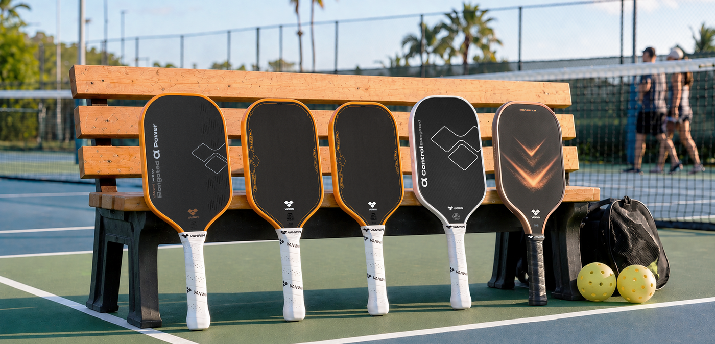 VANWIN carbon fiber and foam-core pickleball paddle lineup displayed on a court bench