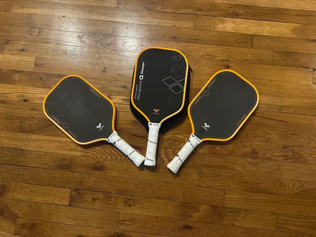 VANWIN Pro T7, Pro T8, and Alpha Power pickleball paddles arranged on a wooden floor