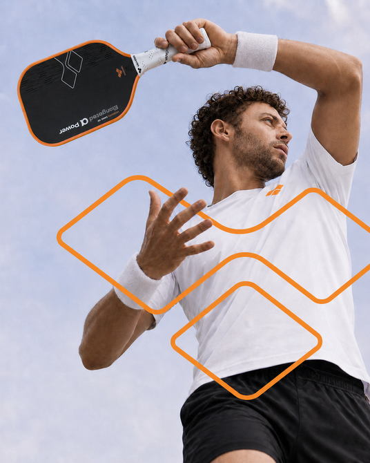 Pickleball player serving with a VANWIN Alpha Power paddle